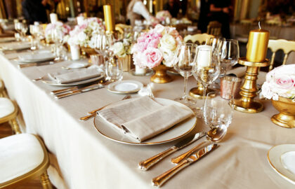 Shiny glassware and cutlery stand on the dinner table decorated