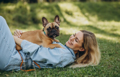 Young woman with her pet french bulldog in park